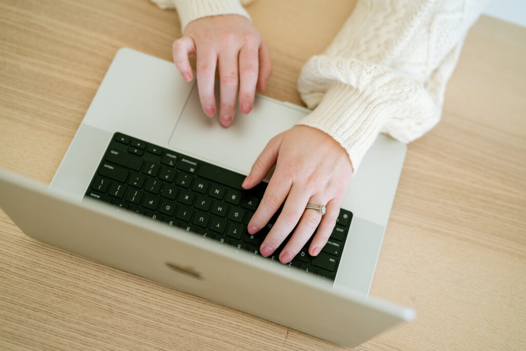 Someone working on their computer, editing as a product photographer, focusing on hands