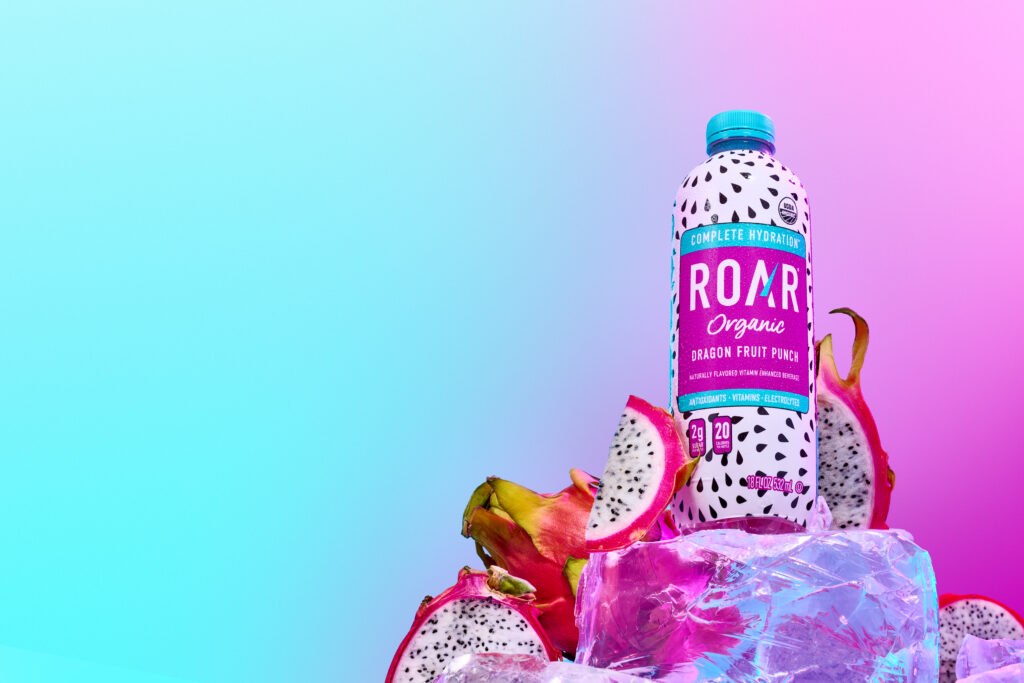 Beautiful product shot of Roar Organic bottle, Dragon Fruit Punch on a large piece of ice.